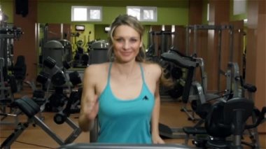 Spor salonunda, ağır çekim fitness yolda kaçan gülümseyen kız