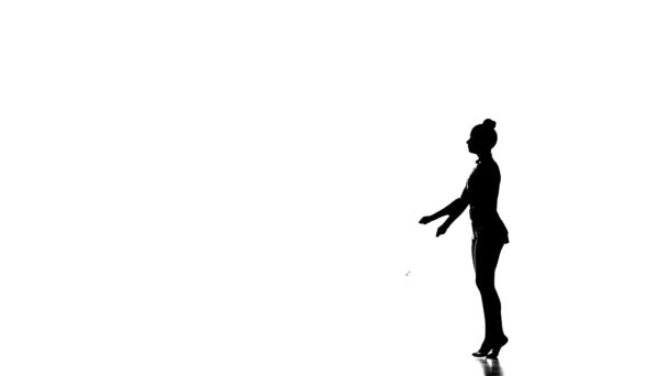 Silhouette Danza ginnasta tenera con mazze da giocoleria, slow motion — Video Stock