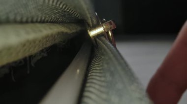 Makro çekim, bavulun içinden görüntü, plastik bir fermuarı parlak ışıklı bir odada metal çekiş sekmesiyle bağlamak..