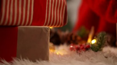 Dekoratif kırmızı böğürtlenleri paketlenmiş bir hediyeye yerleştiriyor, yumuşak ışıklarla şenlikli bir yüzeye yerleştiriyor..