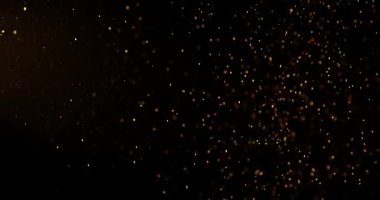 Küçük toz parçacıkları dumanlı havada rastgele uçar, nesneler için boş bir uzay şablonu. Altın tozunun birçok parçacığı ilgi odağı olan boş bir siyah zıt zemine düşer. Yavaş çekim.