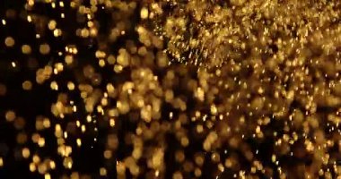 Küçük toz parçacıkları dumanlı havada rastgele uçar, nesneler için boş bir uzay şablonu. Altın tozunun birçok parçacığı ilgi odağı olan boş bir siyah zıt zemine düşer. Yavaş çekim.