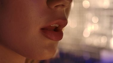 Yumuşak, bulanık bir bokeh arka plan üzerine vurgulanmış bir kadın dudakları üzerine ayrıntılı bir odaklanma.
