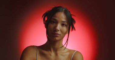 Spot ışığından kırmızı bir daire içinde genç bir Koreli modelin portresi. Konsept güzellik, moda ve doğal kadınsı güzellik..