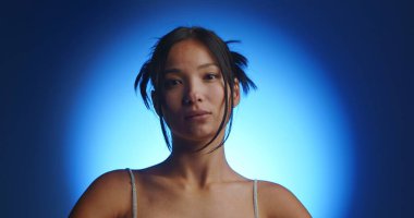 Genç bir Koreli modelin portresi spot ışıklarından mavi bir daire şeklinde. Konsept güzellik, moda ve doğal kadınsı güzellik..