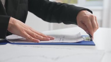 Masanın üstünde bir pano ile evrak işleriyle uğraşan ellere yakın durun. Haritalara, verimliliğe ve organizasyona odaklan..