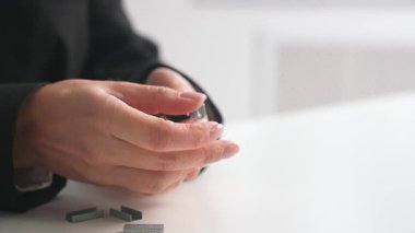 Pembe zımbayı parlak, modern bir ofis alanında metal zımbalarla dolduran kişinin ellerini kapatın..