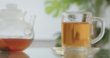 Şeker küpleri yansıtıcı cam bir masanın üzerinde temiz bir kaba düşer. Çay her yöne sıçrar..