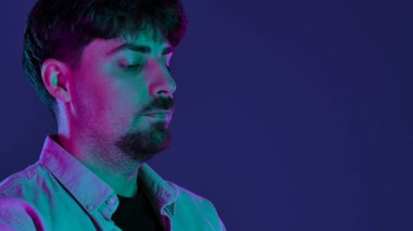 Profesyonel bir stüdyoda, yaratıcı neon ve pembe ışıklı bir stüdyoda fotoğraf çeken bir adamla sahne arkasında..