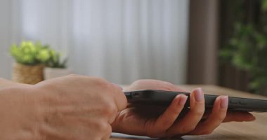 Şarj kablosunu cep telefonuna bağlayan ve ayıran bir kadının elleri modern teknolojiyi vurguluyor..