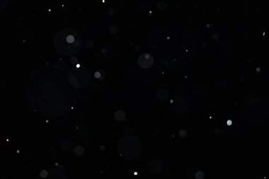 Dumanlı havada rastgele uçuşan küçük toz bulutu, nesne reklamları için boş uzay şablonu. Düşük ışıkta beyaz toz parçacıkları boş siyah kontrastlı arka planda, yakın çekim.