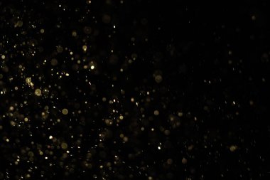 Siyah bir arka plan üzerinde Bir ışık ışını içinde yüzen toz yükselen küçük parçalar. Uzayda hızla hareket eden rüzgar tarafından uçurulmuş gibi rastgele dönüyor. Her biri bağımsız ve dinamik uçan.