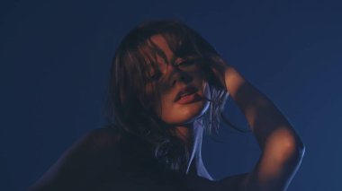 Etkileyici bir kadın portresi dramatik düşük ışıkta, gizemli ve cezbedici bir atmosfer yaratıyor..