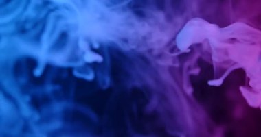 Yumuşak, soyut bir arka plan. Mavi mor dumanlı bulutlar havaya yükseliyor ve koyu bir arkaplanda kıvrılıyor. Modern tasarımlar, sunumlar, posterler, web afişleri, duvar kağıtları için mükemmel. Yavaş çekim.