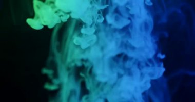 Yumuşak, soyut bir arka plan. Mavi yeşil dumanlı bulutlar havaya yükseliyor ve koyu bir arkaplanda kıvrılıyor. Modern tasarımlar, sunumlar, posterler, web afişleri, duvar kağıtları için mükemmel. Yavaş çekim.