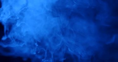 Havaya yükselen ve karanlık bir arka planda dönen çok renkli duman bulutları olan yumuşak soyut bir arka plan. Modern tasarımlar, sunumlar, posterler, web afişleri, duvar kağıtları için mükemmel. Yavaş çekim.