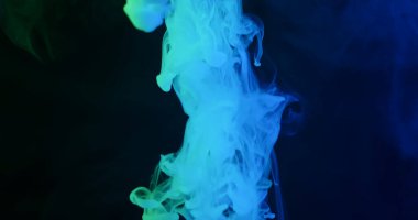 Karanlık bir arka planda hareketli turkuaz ve mavi duman sütunu, modern tasarımlar ve fütüristik planlar için mükemmel, rüya gibi soyut bir doku yaratıyor..