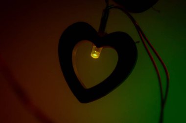 Sıcak, pırıl pırıl bir LED ışığı ahşap bir kalp şeklinde parlar, samimi ve romantik bir atmosfer yaratır..