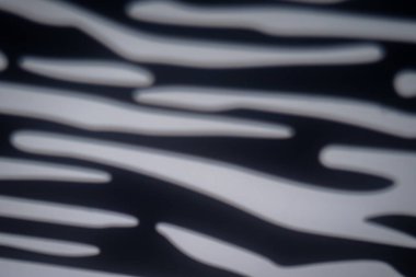 Bir gobo projektör tarafından oluşturulan bulanık siyah ve beyaz zebra çizgileri, arka plan ve modern tasarım için ideal soyut bir model oluşturuyor..