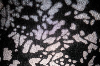 Soyut ışık noktalarının yakın çekimleri koyu dokulu yüzeylere yansıtılarak modern arkaplanlar için yüksek kontrastlı organik desenler oluşturur..