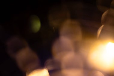 Karanlık bir arka planda yumuşak altın bokeh ışıkları, neşeli, romantik ya da sinematik tasarım projeleri için mükemmel sıcak, rüya gibi bir atmosfer yaratıyor..