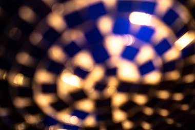 Mavi parlayan ışık ve spiral yansımaları olan bir disko ayna topunun soyut görüntüsü ışıltı ve bokeh ile dolu dinamik bir fütüristik arka plan yaratır..