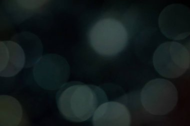 Odak dışı yumuşak deniz mavisi bokeh daireler koyu arkaplan üzerinde, karamsar bir soyut doku oluşturarak gece sahneleri, kopyalama alanı veya üstüste bindirmeler için.