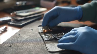 Teçhizat tezgahında alet çantası düzenleyen eldivenli bir teknisyenin yakın görüntüsü, çalışma alanındaki hassasiyeti vurguluyor..