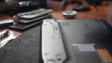 Bir teknisyen dikkatli bir şekilde bir dizüstü bilgisayarı tamir etmek için hassas aletler kullanır. Alet seti ve odak noktası teknik uzmanlık gösteriyor. Yavaş çekim.