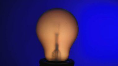 Işıl ışıl ampul koyu mavi bir arkaplan karşısında çarpıcı bir görsel etki yaratıyor..