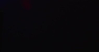 Karanlık bir duvarda parlayan bir stüdyonun projeksiyonundan çıkan çok renkli gobo yansımalar. Mavi, yeşil, kırmızı ve mor şekilli soyut ışık deseni, video üretimi için sinematik bir arkaplan oluşturur.