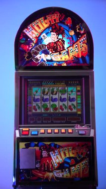 Dnipro, Ukraine - February 17, 2026: Vintage casino slot machine with a colorful Multi Game joker design and Aztec Gold game on the screen, standing against a vibrant multicolored gradient background. Vertical video.