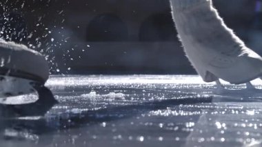 Artistik patinajcıların yakın açıları buz keserken kapalı bir alanda dramatik spreyler sıkarlar. Hareketli, enerjik ve atletik performanslı dinamik kış sporu sahnesi. Yavaş çekim.