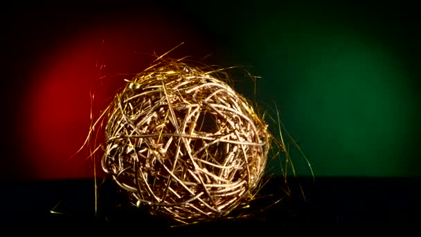 Giocattolo d'oro lucido per Natale o Capodanno, rotazione, su rosso e verde — Video Stock