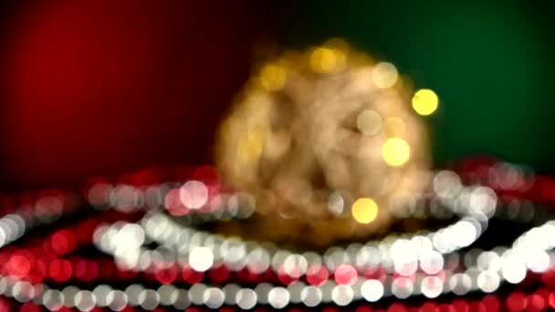 Giocattolo d'oro insolito per Natale o Anno nuovo e perline, rotazione, su rosso e verde, bokeh, cambiamento dinamico di attenzione — Video Stock