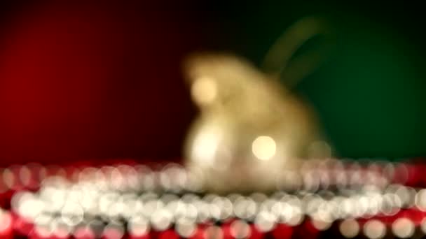 Brinquedo dourado excepcional brilhante de Natal ou Ano Novo e contas, rotação, em vermelho e verde, bokeh, modificação dinâmica de foco — Vídeo de Stock