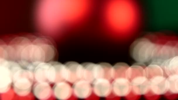 Giocattolo rosso lucido per Natale o Capodanno e perline, rotazione, su verde, bokeh, cambiamento dinamico di messa a fuoco, primo piano — Video Stock