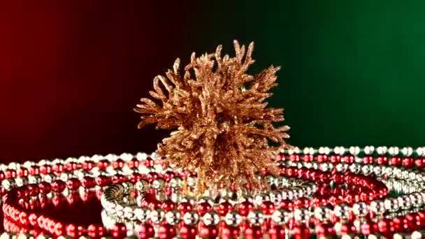 Unusual coral toy for Christmas or New Year and beads, rotation, on red and green, reflection — Stock Video