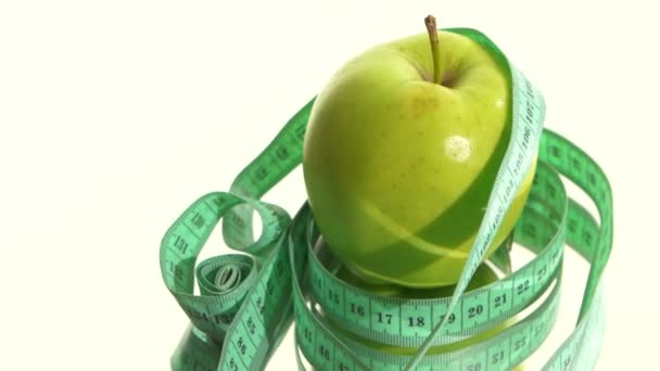 Pomme verte avec ruban à mesurer sur blanc, rotation, réflexion — Video