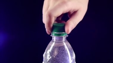 Eller koyu, yavaş hareket, sıçrama, sprey, kabarcıklar üzerinde tatlı su yeşil bir şişe açma