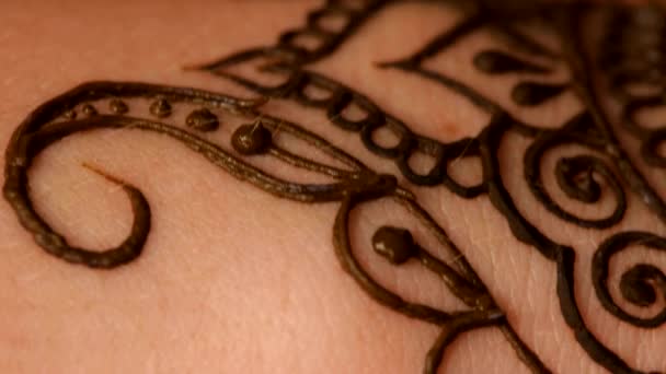 Femme main étant décorée avec tatouage au henné, mehendi, sur blanc, gros plan, cam se déplace vers le haut 