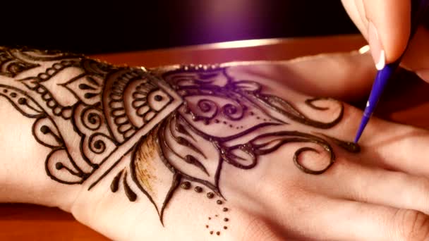 Mano delle donne essendo decorato con tatuaggio all'hennè, mehendi, su nero — Video Stock