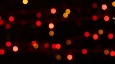 Olağandışı dekorasyon - bir yuvarlak kırmızı oyuncak Noel ağacı, bokeh, ışık, siyah, garland, cam üzerinde sağa taşır.