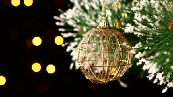 Ongebruikelijke decoratie - ronde bruin speelgoed op kerstboom, bokeh, licht, zwart, garland — Stockvideo