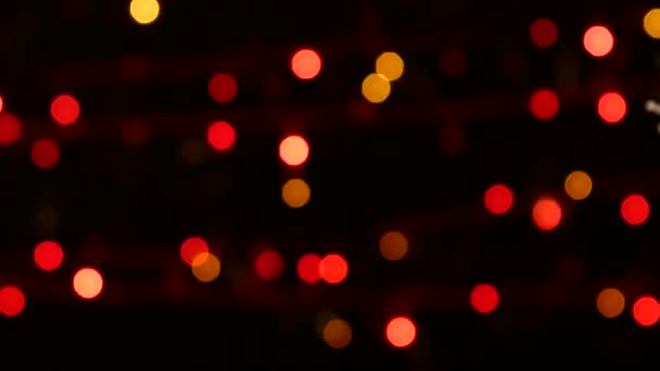 Olağandışı dekorasyon - bir yuvarlak kırmızı oyuncak Noel ağacı, bokeh, ışık, siyah, garland, cam üzerinde sağa taşır. — Stok video