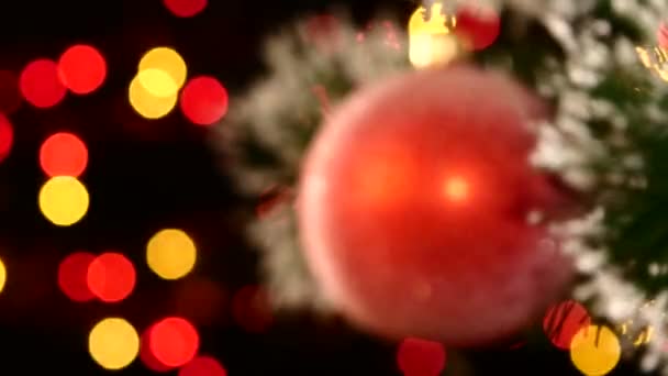 Ungewöhnliche Dekoration - rundes, rot glänzendes Spielzeug am Weihnachtsbaum, Bokeh, hell, schwarz, Girlande, dynamischer Schwerpunktwechsel — Stockvideo