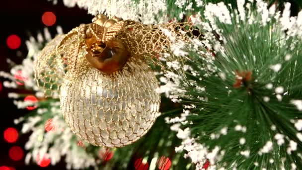 Decoración inusual: un juguete redondo de oro brillante en el árbol de Navidad, bokeh, luz, negro, guirnalda, primer plano — Vídeo de stock