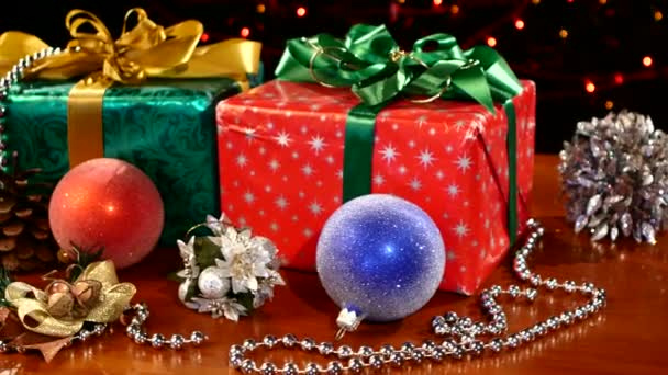 Weihnachtsgeschenke, Deko-Spielzeug und Perlen, Nocke bewegt sich nach links, Bokeh, Girlande, Licht, auf schwarz — Stockvideo