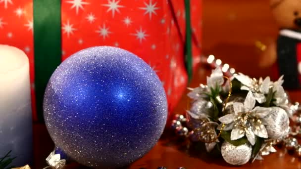 Presentes de Natal, brinquedos de decoração com vela e contas, cames se move para a esquerda, bokeh, guirlanda, luz, em preto, close — Vídeo de Stock