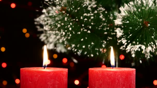 Κορυφή των δύο κόκκινα κεριά με στολίδια Χριστουγεννιάτικα και δέντρο στο μαύρο, bokeh, φως, γιρλάντα — Αρχείο Βίντεο